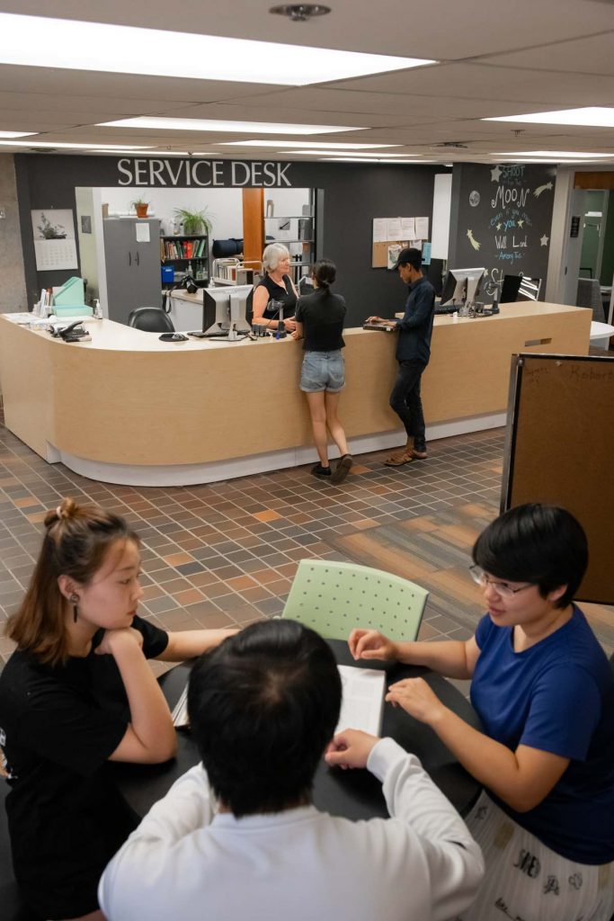 UPEI's Robertson Library service desk with students seeking assistance